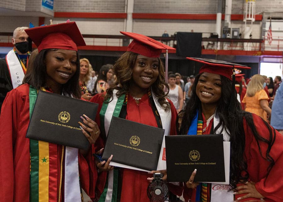 Undergraduate students holding diploma covers